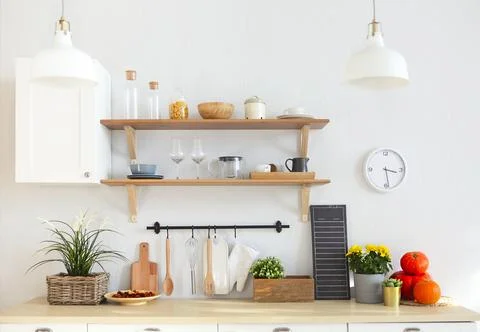 Interior of empty modern white kitchen with various objects on the table Stock Photos