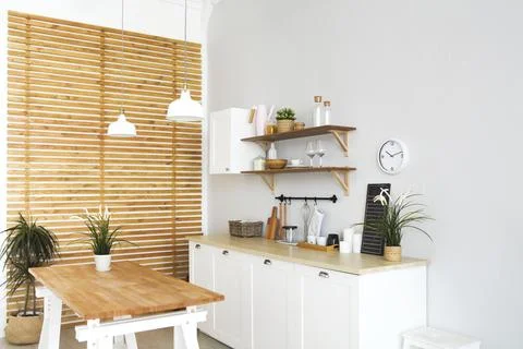 Interior of empty modern white kitchen with various objects on the table Stock Photos