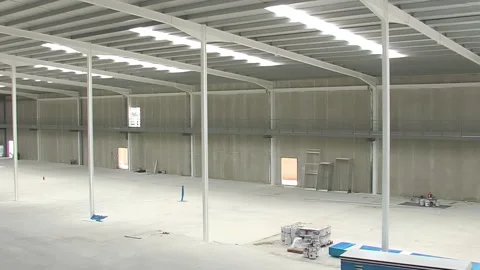 Interior of a empty ndustrial warehouse in construction, pan Video stock 250377184