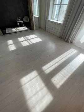 Interior of an empty white and black room with windows and sun rays Foto stock