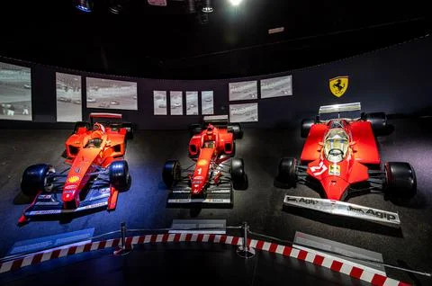 Interior exhibit showcasing an array of Ferrari racecars at a museum. Foto stock