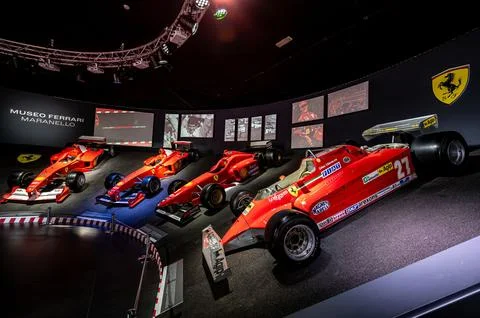 Interior exhibit showcasing an array of Ferrari racecars at a museum. Foto stock