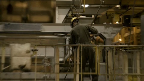 Interior Factory - Worker tending to steel fabrication machine - Wide Shot - Stock Footage 89980587