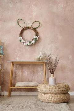 Interior of festive room with table, decorations, ottomans and Easter wreath  Stock Photos