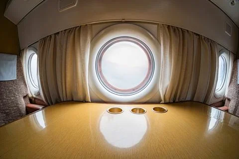 Interior of a first-class aircraft cabin, featuring soft lighting, wooden des Stock Photos
