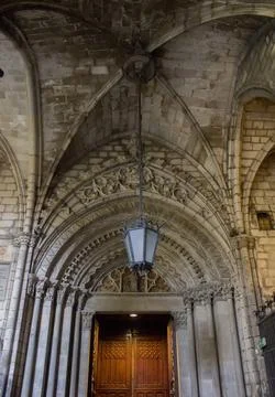 Interior of gothic temple with old lamp on ceiling and wooden door Stock Photos
