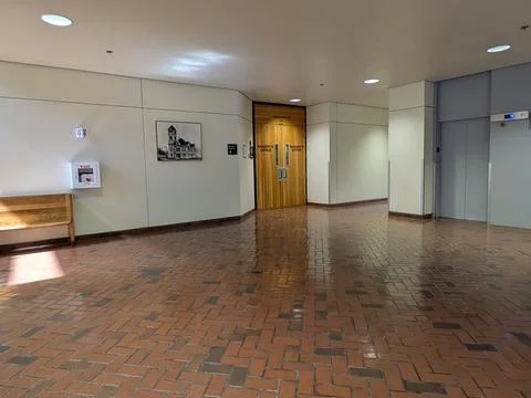 Interior hallway featuring Sheriff’s Office wooden doors, brick flooring 스톡 사진