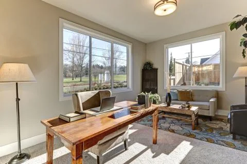 Interior of home office with soft gray walls features Wood desk with gray wingba Stock Photos