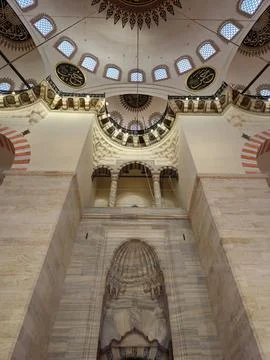 Interior of Islamic mosque prayer hall with ornate arches and dome Stock Photos