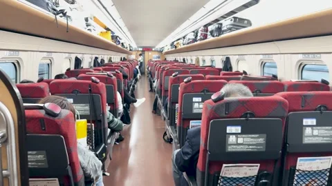Interior of a Japanese Shinkansen Bullet Train with Red Seats and Passengers 動画素材 335852919