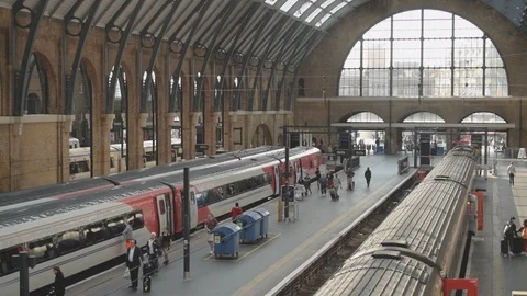 Interior of Kings Cross train station with commuters and trains at platforms Stock Footage 94498157