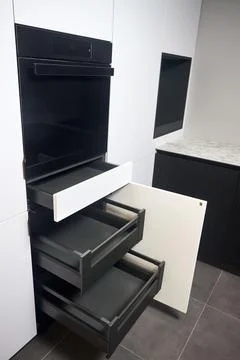 Interior of kitchen with lots of built-in upper and lower cabinets, oven, d.. Stock Photos