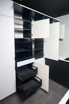 Interior of kitchen with lots of built-in upper and lower cabinets, oven, dra Stock Photos