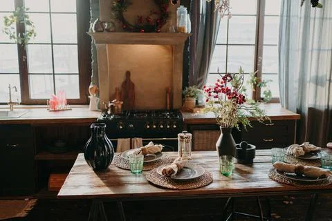 Interior of kitchen. Served dining table with plates glasses floral decor Foto stock