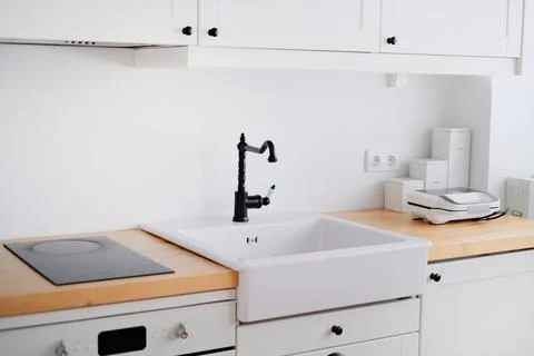 The interior of a kitchen in white tones with a sink, sandwich maker, stove Stock Photos