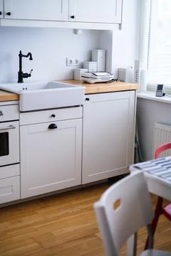 The interior of a kitchen in white tones with a sink, sandwich maker, stove Stock Photos