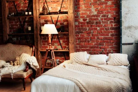 Interior with a large bed and a brick wall Stock Photos