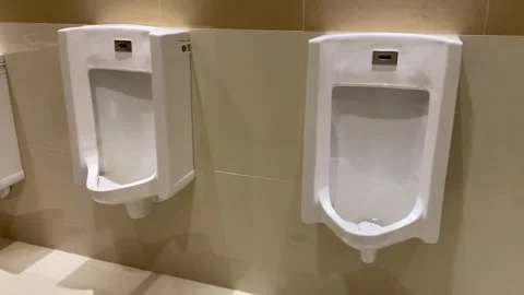 Interior layout of a modern men's restroom with urinals and stalls Stock Footage 332397331