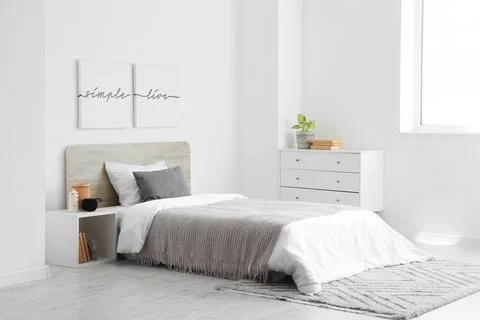 Interior of light bedroom with bed and sound speaker on table Stock Photos