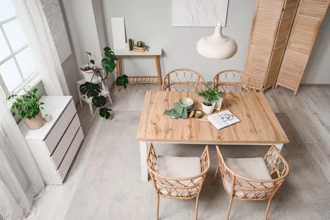 Interior of light dining room with table, folding screen and plants, top view Stock Photos
