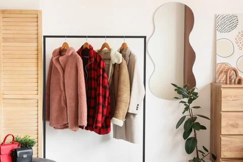 Interior of light dressing room with mirror and coat rack Stock Photos