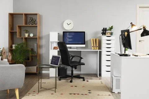 Interior of light office with programmer's desks, shelf unit and lamps Stock-Fotos