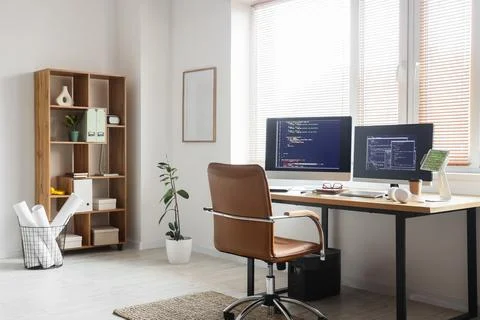 Interior of light office with programmer's workplace, shelf unit and plants Stock-Fotos