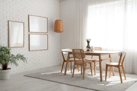 Interior of light room with blank frames, lamp and dining table Stock Photos
