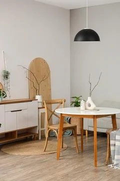 Interior of light room with dining table, sofa and commode Stock Photos