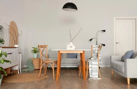 Interior of light room with dining table, sofas and lamps Stock Photos