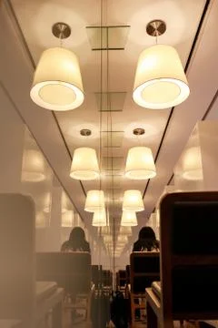 Interior lighting in modern library or cafe, reflection of ceiling lamps Stock Photos