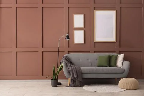 Interior of living room with blank frames, grey sofa and lamp Фото