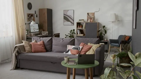 Interior of Living Room Featuring Grey Couch and Green Coffee Table with Laptop Stock Footage 335150342