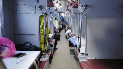 Interior of a long-distance sleeper train carriage with passengers traveling Stock Footage 344698132