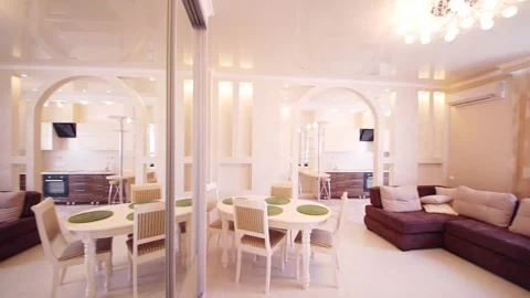 Interior of luxurious living room with table, sofa, kitchen in apartment 動画素材 276358997