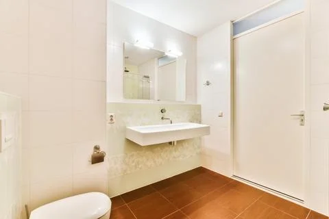The interior is a mind-blowing bathroom with a brown tiled floor Stock Photos