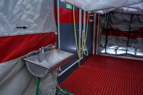 Interior of mobile plastic decontamination shower tent with small steel wash Stock Photos
