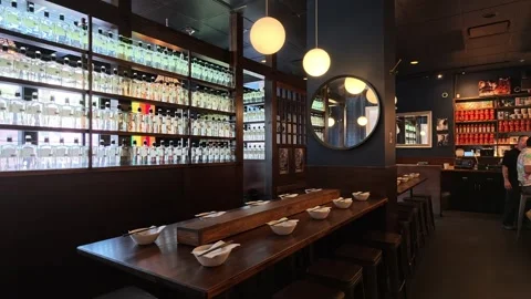 Interior of modern Asian restaurant with sake bottles and dining table Stock Footage 339118864