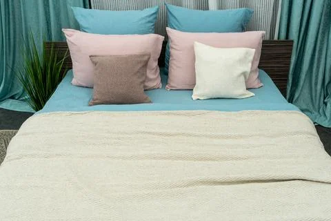 The interior of a modern bedroom with a large bed, colorful pillows and blank Foto stock