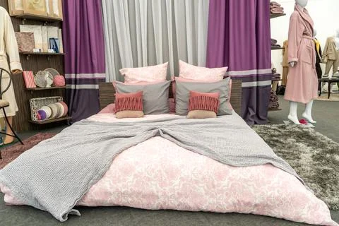 The interior of a modern bedroom with a large bed, colorful pillows and blank Stock Photos