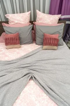 The interior of a modern bedroom with a large bed, colorful pillows and blank Foto stock