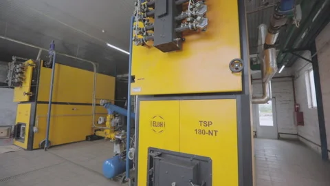 The interior of a modern boiler room at the plant. A modern wood sawdust heating Vidéo 166310734