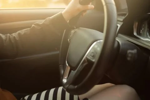 Interior of a modern car driven by a beautiful woman in short striped skirt s Stock Photos