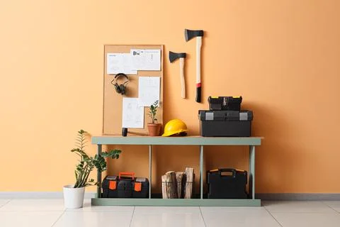 Interior of modern carpenter's workshop with table, cork board, tool boxes an Stock Photos