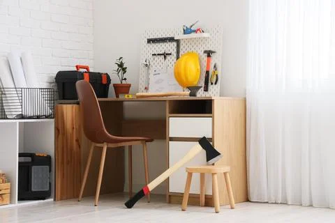 Interior of modern carpenters workshop with table, pegboard, tools and axe Stock Photos