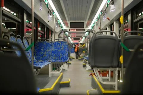 Interior of modern city low floor city tram with seats and hand grips in nigh Stock Photos
