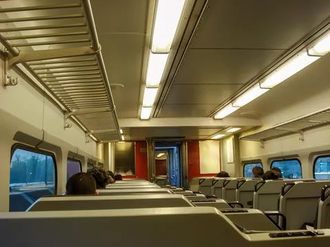 Interior of a Modern Commuter Train in Motion with Passengers Stock Photos
