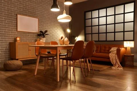 Interior of modern dining room with glowing lamps, sofa and table Stock Photos