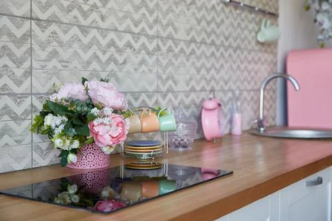 Interior of a modern kitchen set with a bouquet of flowers in a vase. background Stock Photos