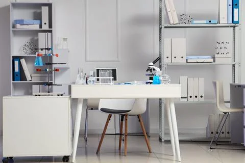Interior of modern laboratory with microscope, stand and different water samp Фото